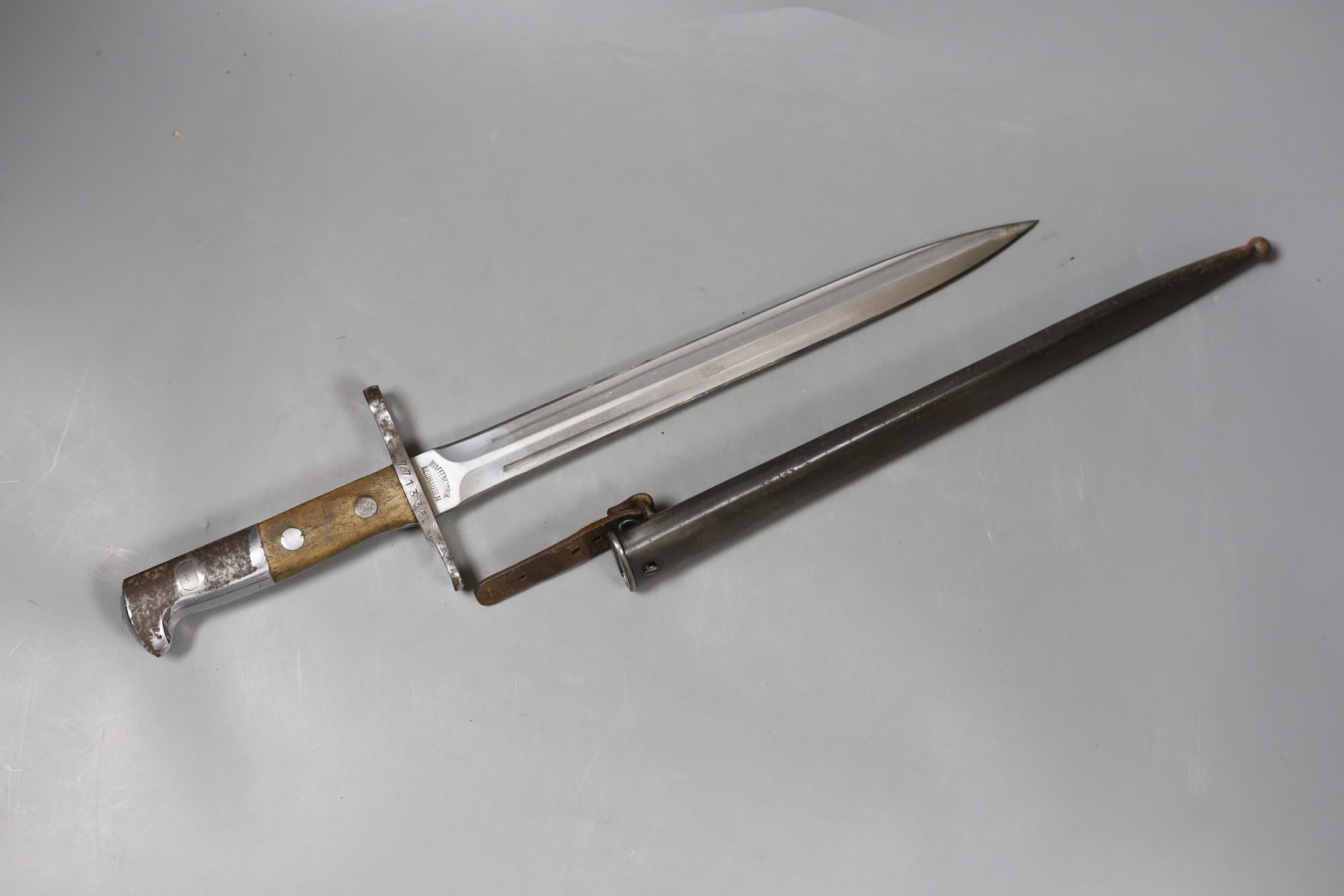 A Swiss bayonette, the blade marked WAFFENFABRIK NEUHAUSEN, hilt serial number 771335, with sheath